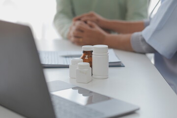 Mature Asian male doctor talking with his patient, explaining the procedure to old lady.