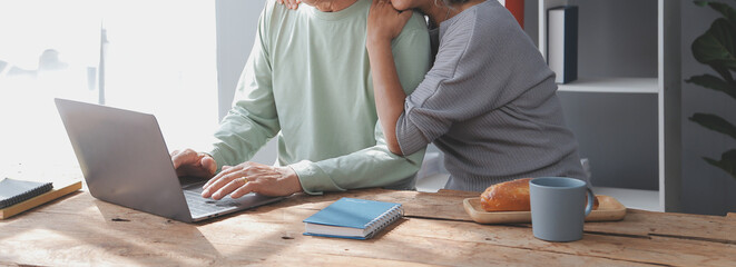 Fototapeta premium Happy mature couple using laptop at home
