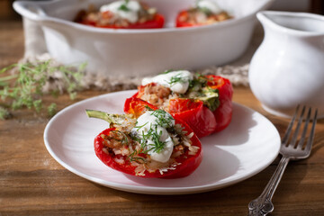 Stuffed paprika peppers with rice and minced meat, tomatoes and sour cream