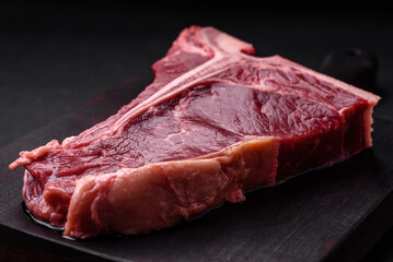 Raw juicy beef t-bone steak with salt, spices and herbs