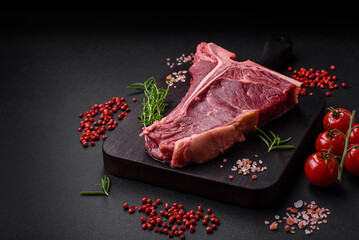 Raw juicy beef t-bone steak with salt, spices and herbs