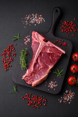 Raw juicy beef t-bone steak with salt, spices and herbs
