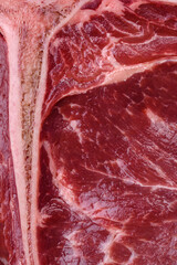 Raw juicy beef t-bone steak with salt, spices and herbs