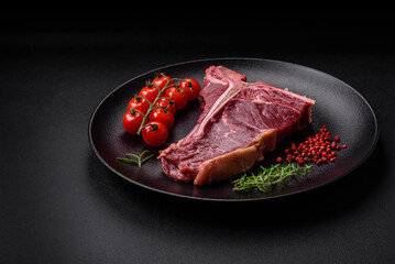 Raw juicy beef t-bone steak with salt, spices and herbs