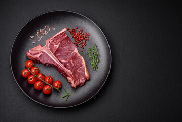 Raw juicy beef t-bone steak with salt, spices and herbs