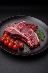 Raw juicy beef t-bone steak with salt, spices and herbs