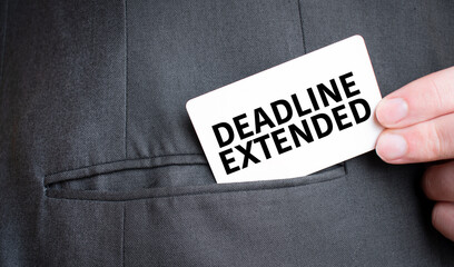 Card with DEADLINE EXTENDED text in pocket of businessman suit. Investment and decisions business...