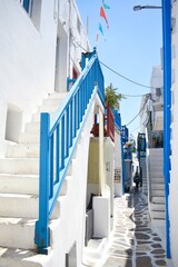 White stairs with colorful railings along a cobblestone road in Mykonos
