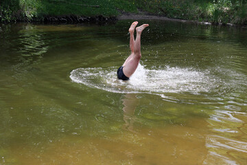 Człowiek skacze do wody na głowę w niebezpiecznym miejscu. - obrazy, fototapety, plakaty