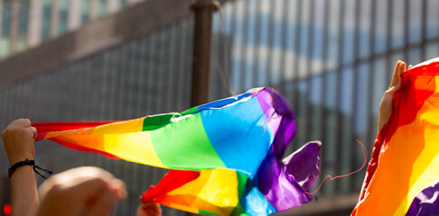 Bandeira colorida, símbolo do orgulho gay LGBT+, tremulando na Avenida Paulista durante a 27ª edição, da Parada do Orgulho LGBT+ de São Paulo, Brasil.   - obrazy, fototapety, plakaty