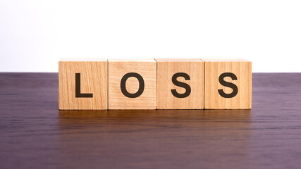 wooden cubes with text LOSS on wooden table. financial loss busines concept