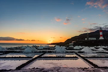 Abwaschbare Fototapete Kanarische Inseln Sunset at the salt flats directly on the Atlantic coast. The sea salt shines romantically in the light