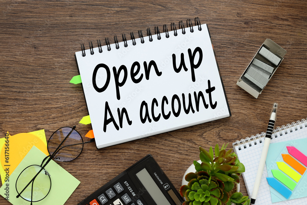 Poster on a wooden background an open notepad with bookmarks. word on page. open up an account