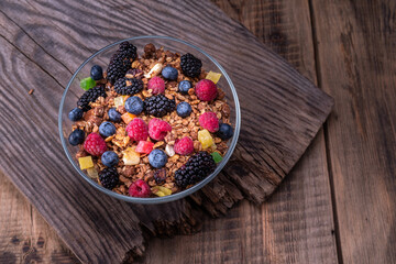 Large glass toe with berries on a wooden table. Free space in the composition. Negative space.