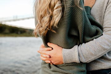 Young couple embracing beside the river