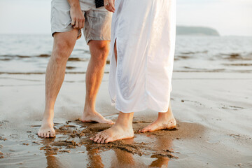 A bride and groom standing in the sand at sunset after an elopement at New River Beach, New...