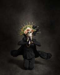 Studio portrait of Drag Queen catrin. Catrin dressed in black with flower crown. Makeup for halloween or day of the dead.