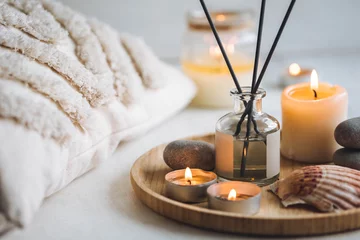 Photo sur Plexiglas Aube Cozy corner for home meditation and relaxation. Aroma diffuser, burning candles, stones for comfort, pleasure, aromatherapy. Decor for apartment, house, indoors design