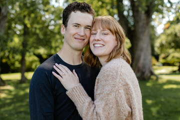 Fototapeta premium Newly engaged couple embracing in Saint Andrews, New Brunswick.