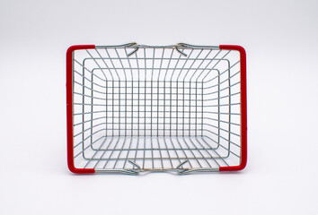 Photo of an empty silver metal wire shopping basket with red handles 