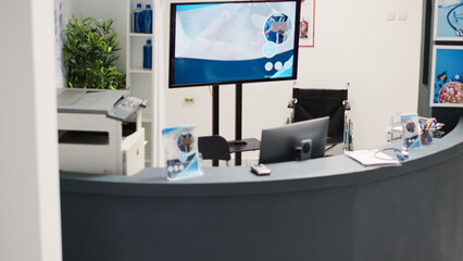 Healthcare facility reception desk in waiting room with registration forms and checkup appointment reports. Empty counter in clinical lobby used for recovery service, cure disease. Handheld shot.