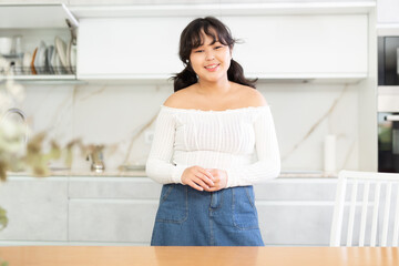 Portrait of young asian girl in the interior of a modern kitchen