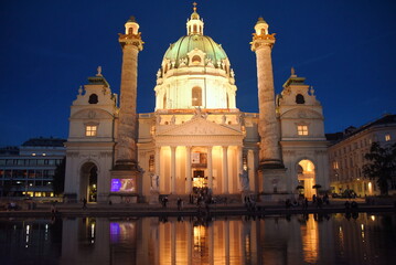 Nächtlich beleuchtete Karlskirche mit Spiegelung auf dem Wasser