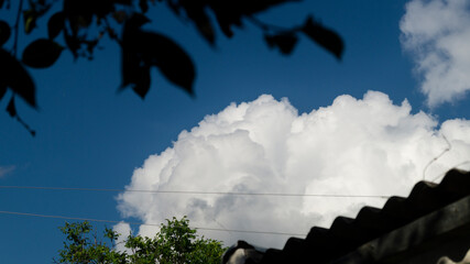 White clouds above the roof. Fluffy white clouds