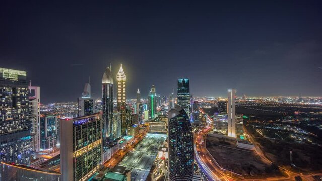 Skyline view of the high-rise buildings on Sheikh Zayed Road in Dubai aerial night panoramic timelapse, UAE. Illuminated skyscrapers in International Financial Centre from above
