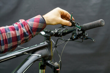 The handlebar of a mountain bike in the workshop on a black background. Replacement of the...