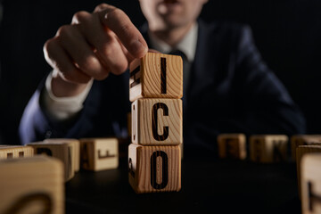 letters of the alphabet of ICO on wooden cubes, ICO - short for initial coin offering