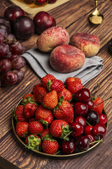 Still life with red plums, paraguayans, grapes, berries