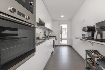 Fototapeta premium Modern kitchen with white handleless cabinets