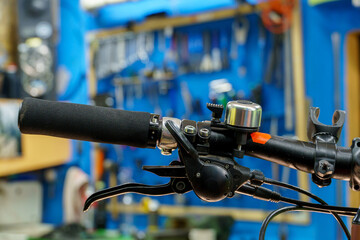 Mountain bike in the workshop on the background of a stand with tools. Bicycle repair before...