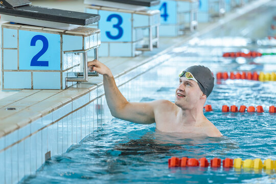 Man swimmer happy at the finish of a race in the pool at competition
