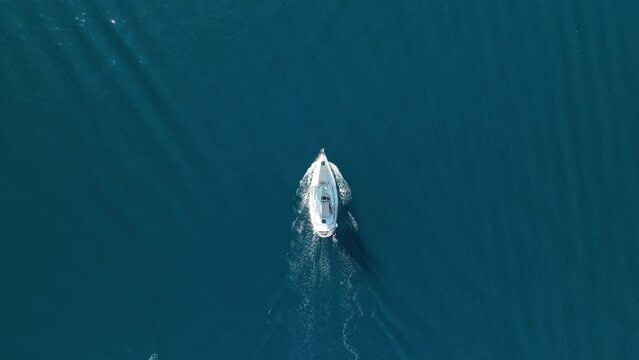 An aerial view of the sail yacht on the blue sea. Transparent clear water in the sea. Summer vacations and travels on a sailing yacht. Summer relaxation.