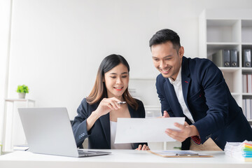 Obraz premium Smart and professional male manager working with his female assistant. check financial reports Analyze financial data with graph papers and laptop with desk.