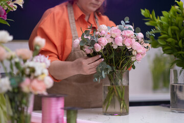 female entrepreneur and owner of the thriving flower shop stands confidently with a bouquet of flowers, a reflection of her success in the small business world