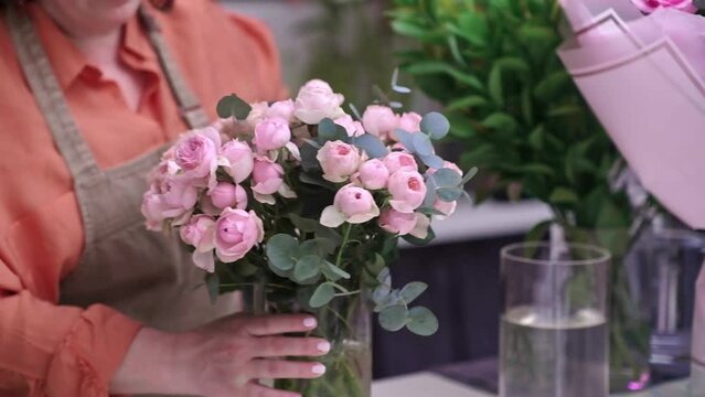hard-working and talented flower shop assistant creates a beautiful and unique bouquet of pink rose flowers, adding a touch of beauty to the small business floral shop