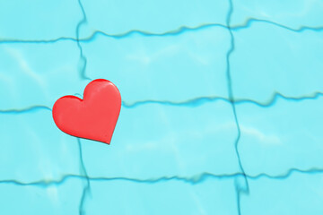 The red heart in the blue pool. The concept of swimming makes the heart healthier and strengthens. Copy space.
