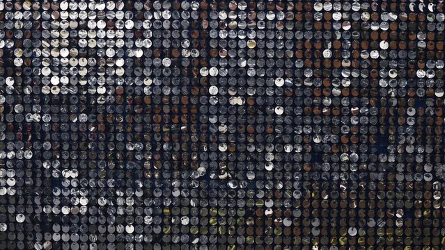 Silver mirror sequins sparkle and move in the wind, dynamic sparkling background