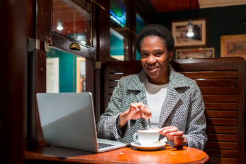 Business woman of African ethnicity in a coffee shop, moment of rest finance woman having a coffee