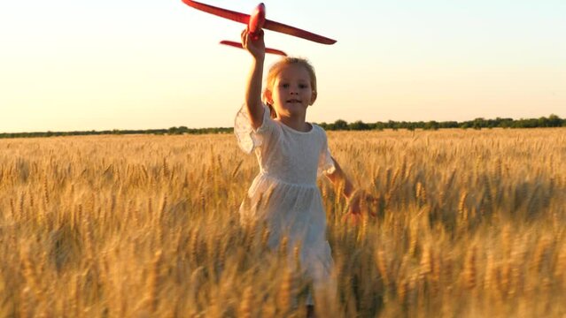 little child girl kid daughter runs through wheat field with toy plane her hand sunset, happy family dream fly, becomes pilot plane children dream, emotional shot, fun dream fantasy, childhood dream