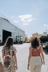 Two woman from the tourists group at the factory "Valor" going during excursion outside the yard.