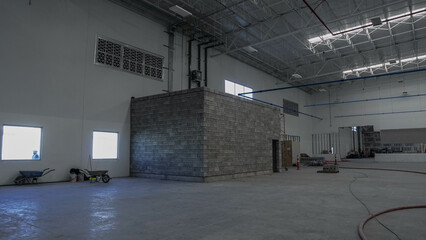 construction de nave industrial en zona industrial, trabajando arduamente albañiles desconocidos