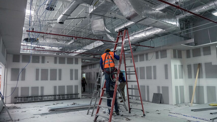 Concrete floor inside industrial building. Use as large factory, warehouse, storehouse, hangar or plant. Modern interior with metal wall and steel structure with empty space for industry, mens working