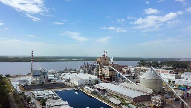 Drone flight elevation over pulp and paper mill on river coast