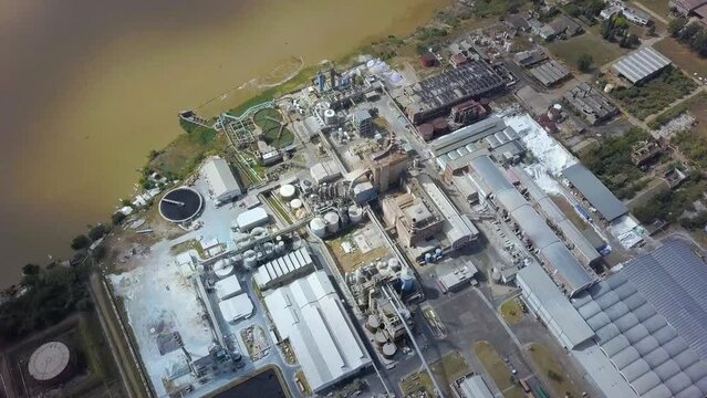 Drone flight over pulp and paper mill on the river coast