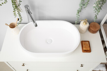 White sink with bath accessories on drawers in room