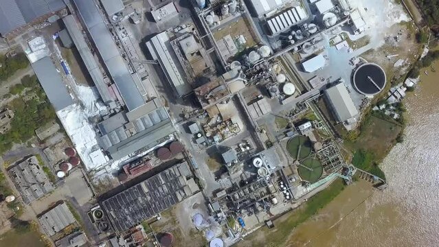 Drone flight over pulp and paper mill on the river coast